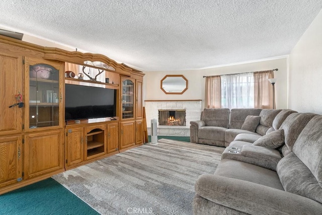 living room featuring carpet flooring, a fireplace, and a textured ceiling