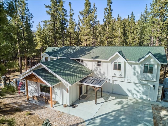 view of front of property with board and batten siding, metal roof, and a shingled roof