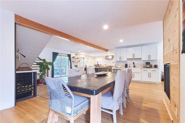 dining space featuring beam ceiling, light wood-style flooring, and recessed lighting