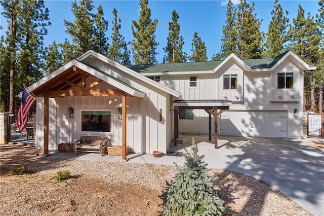 view of front of home featuring an attached garage, a shingled roof, board and batten siding, and concrete driveway