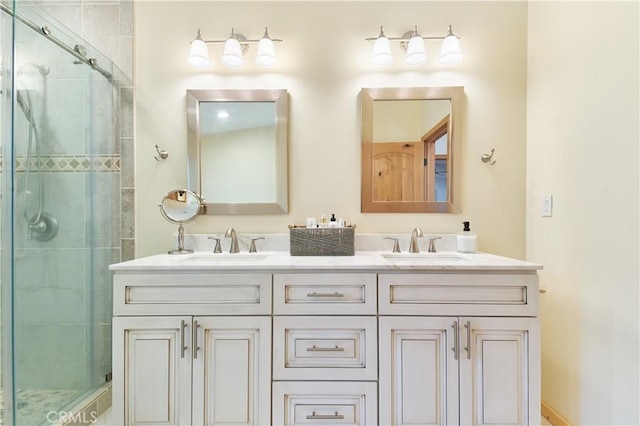 bathroom featuring double vanity, a stall shower, and a sink