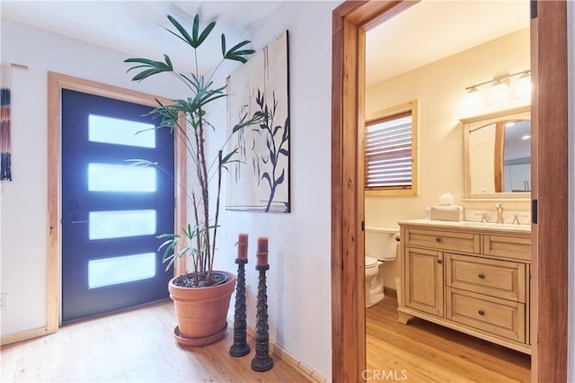 entryway with light wood-type flooring and baseboards