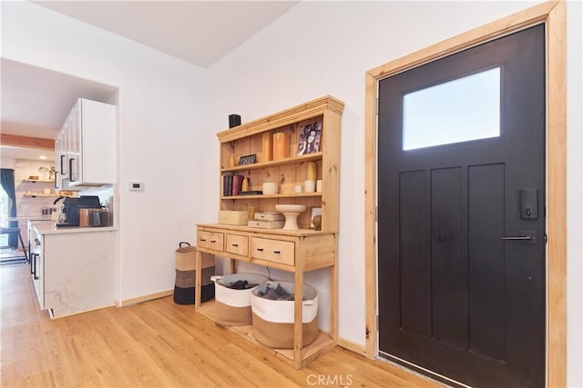 foyer featuring light wood-style floors and baseboards