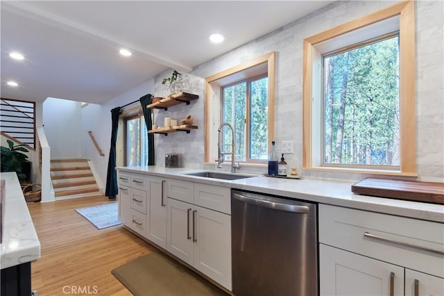 kitchen featuring recessed lighting, a sink, white cabinetry, stainless steel dishwasher, and light wood-type flooring