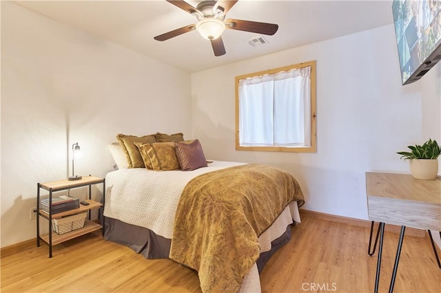 bedroom with baseboards, visible vents, ceiling fan, and wood finished floors