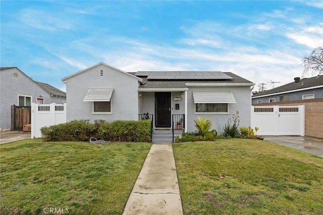 view of front of house featuring fence, solar panels, a front yard, and a gate