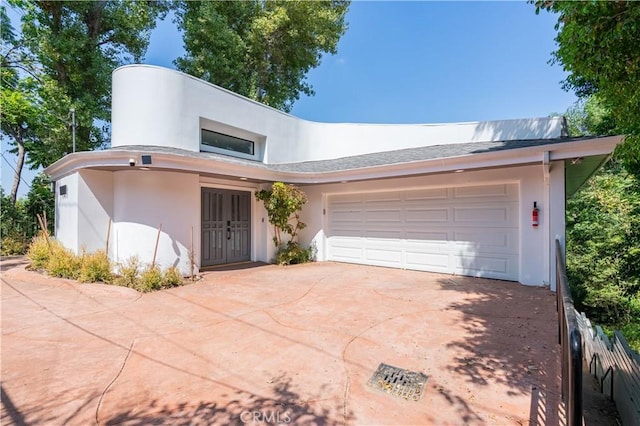 view of front of house featuring a garage, driveway, and stucco siding