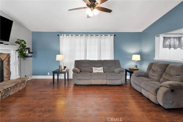 living room featuring baseboards, lofted ceiling, ceiling fan, wood finished floors, and a fireplace