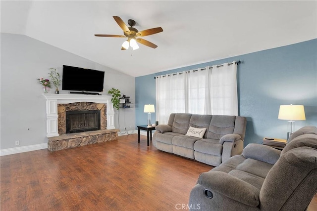 living room featuring lofted ceiling, ceiling fan, a fireplace, wood finished floors, and baseboards