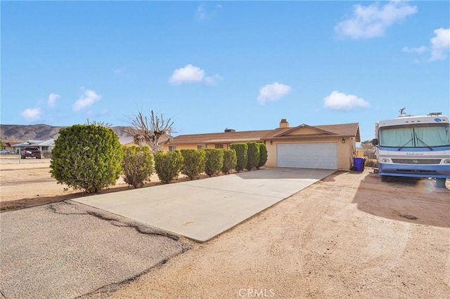 view of front facade with a garage, driveway, and stucco siding