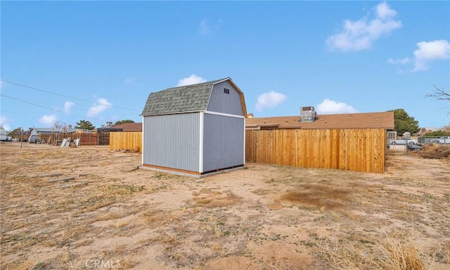 view of yard featuring fence private yard, an outdoor structure, and a shed