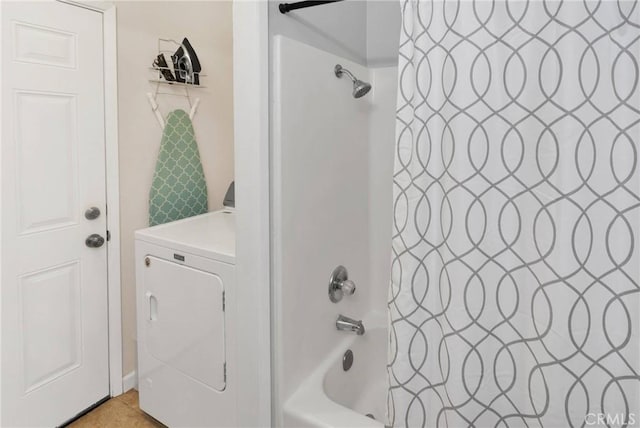 bathroom with washer / clothes dryer and shower / bathtub combination with curtain