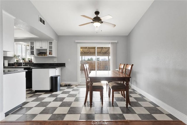 dining space with a wealth of natural light, dark floors, visible vents, and baseboards