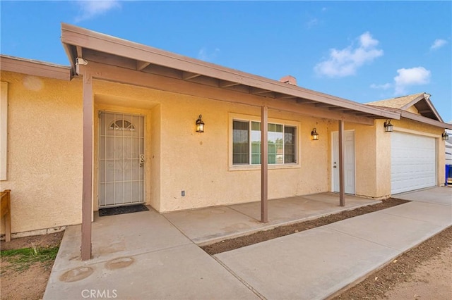 exterior space with a garage and stucco siding