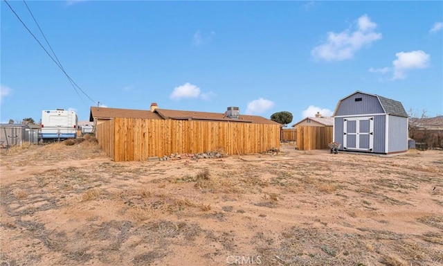 view of yard featuring an outbuilding, a shed, and fence