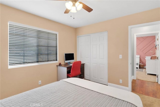 bedroom with ceiling fan, baseboards, a closet, and wood finished floors