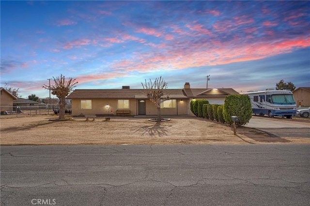 single story home featuring fence, concrete driveway, and stucco siding