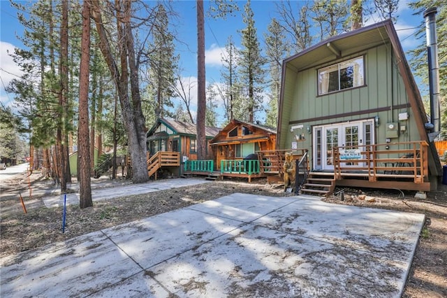 rear view of house with a patio area, a deck, and board and batten siding