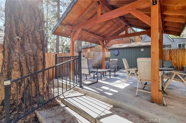 view of patio / terrace featuring a fenced backyard, a shed, and an outdoor structure