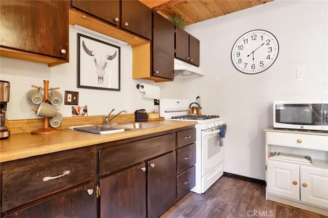 kitchen with dark wood finished floors, white gas stove, dark brown cabinetry, a sink, and under cabinet range hood