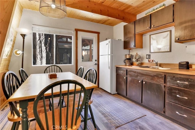 kitchen featuring wood finished floors, wood ceiling, a sink, beam ceiling, and freestanding refrigerator