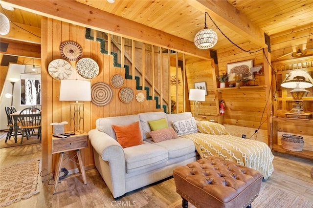 living area with beamed ceiling, wood finished floors, wood ceiling, and wooden walls