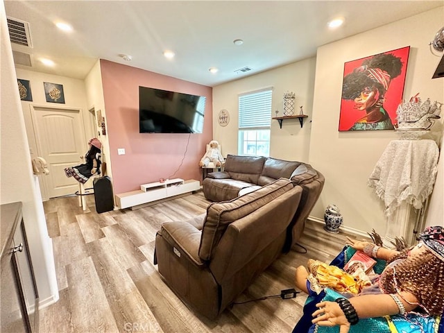 living area featuring baseboards, visible vents, wood finished floors, and recessed lighting