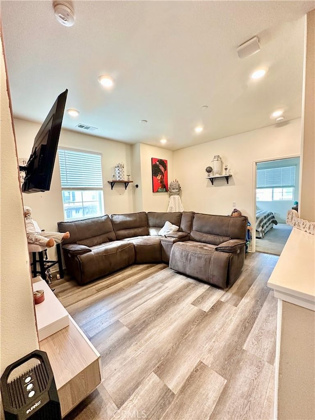 living room with light wood finished floors, visible vents, and recessed lighting