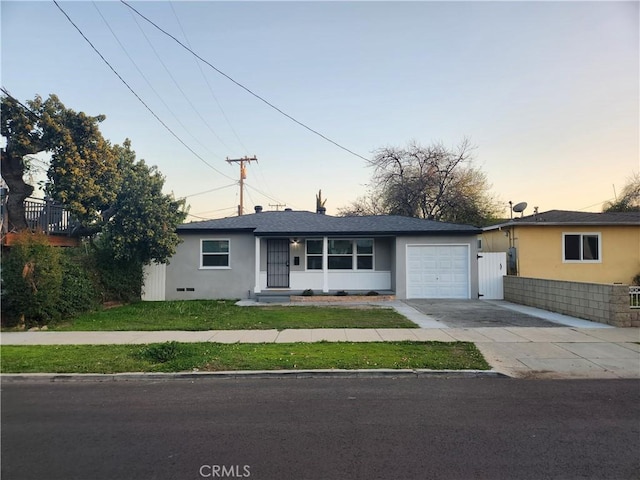 single story home with driveway, a front yard, a garage, and stucco siding