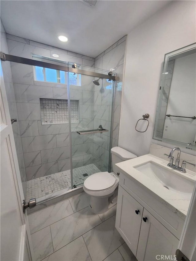 bathroom featuring marble finish floor, recessed lighting, toilet, a stall shower, and vanity