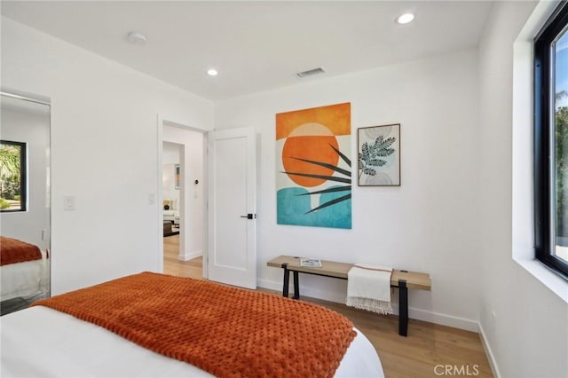 bedroom featuring baseboards, light wood finished floors, visible vents, and recessed lighting