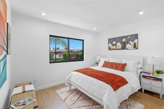 bedroom featuring baseboards, wood finished floors, and recessed lighting