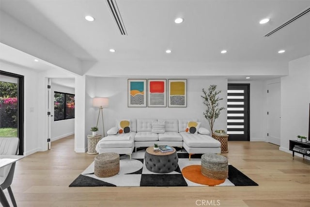 living room with visible vents, baseboards, light wood-style flooring, and recessed lighting