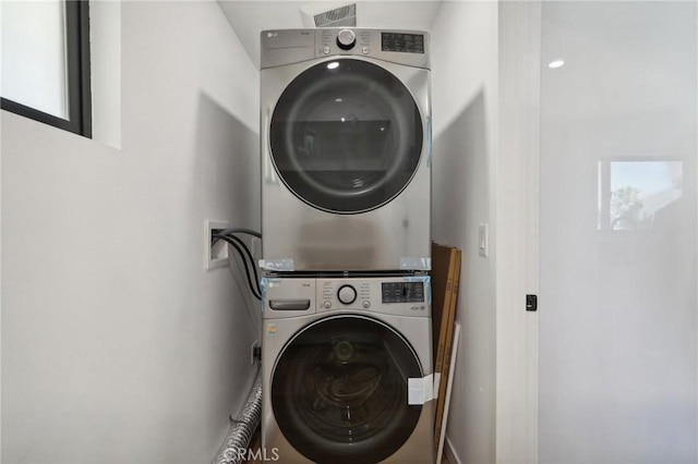 clothes washing area with laundry area and stacked washer / dryer