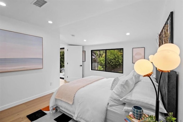 bedroom featuring baseboards, wood finished floors, visible vents, and recessed lighting