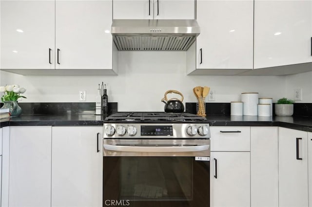 kitchen with stainless steel gas range, dark countertops, white cabinetry, and under cabinet range hood