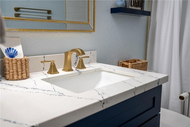 bathroom with a textured wall and vanity