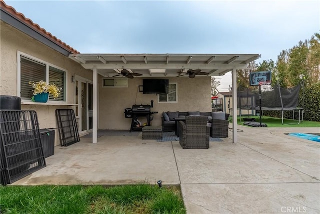 view of patio featuring a trampoline, area for grilling, an outdoor living space, and a ceiling fan