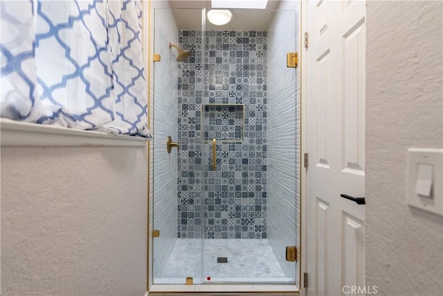 full bath featuring a textured wall and a stall shower