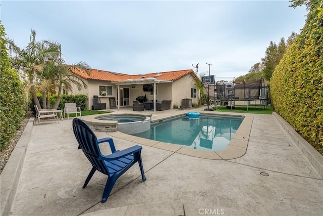 view of pool featuring a trampoline, a patio area, and a pool with connected hot tub