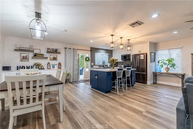 kitchen with light countertops, appliances with stainless steel finishes, light wood-type flooring, and visible vents