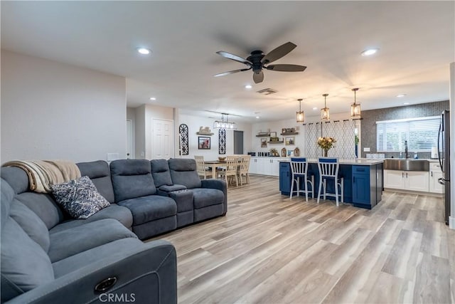 living room with light wood finished floors, a ceiling fan, visible vents, and recessed lighting