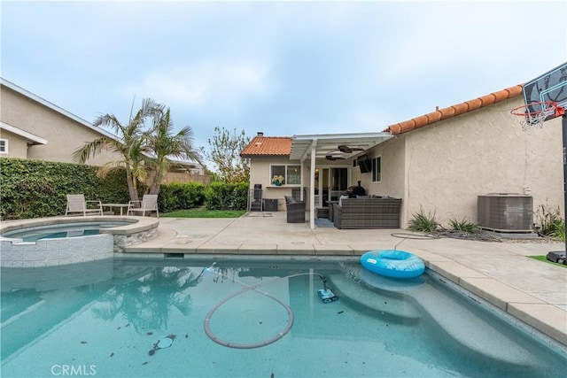 view of swimming pool with a ceiling fan, a patio, a pool with connected hot tub, an outdoor living space, and central AC