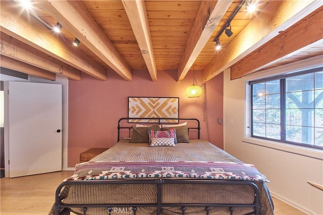 bedroom featuring light wood-style flooring, wooden ceiling, rail lighting, and beam ceiling