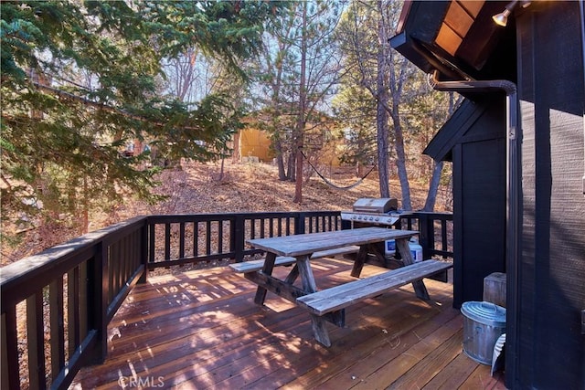 deck featuring outdoor dining area and a grill