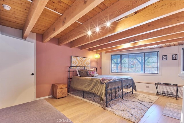 bedroom with wood ceiling, baseboards, wood finished floors, and beamed ceiling