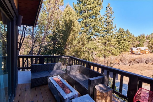 wooden deck featuring an outdoor living space with a fire pit