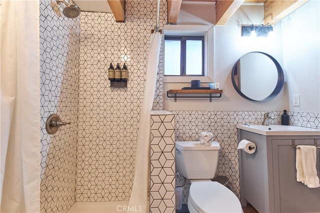 bathroom with tile walls, toilet, wainscoting, a shower stall, and vanity