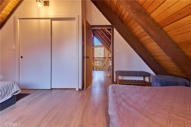 unfurnished bedroom with a closet, wooden ceiling, lofted ceiling with beams, and wood finished floors