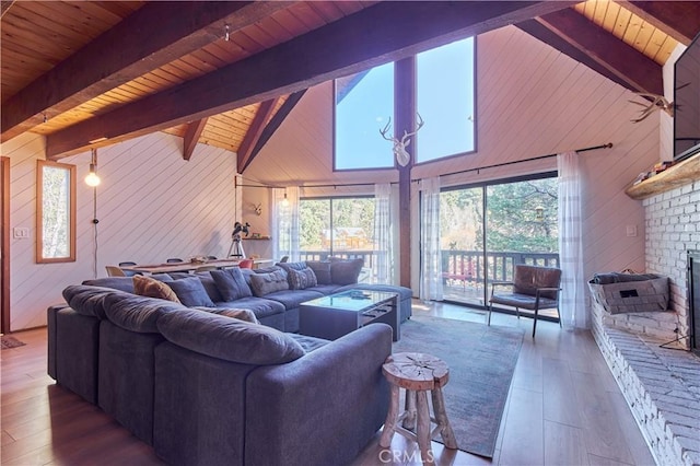 living area featuring a healthy amount of sunlight, a brick fireplace, and wooden walls